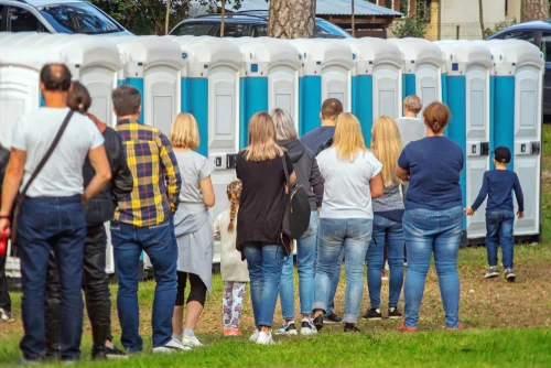 Group,of,people,standing,near,portable,toilets,in,a,park